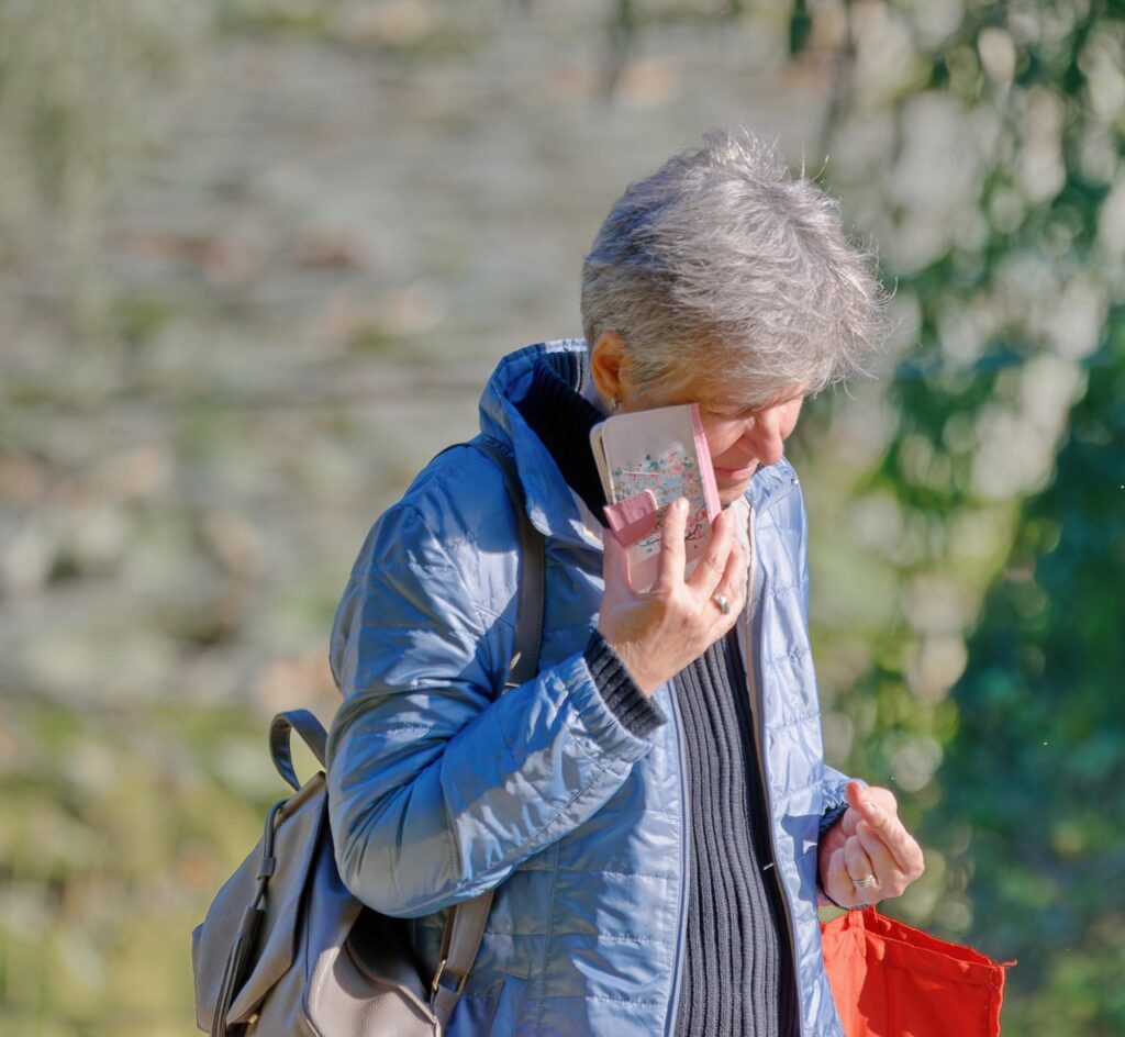 Older church member taking a phone broadcast call outdoors