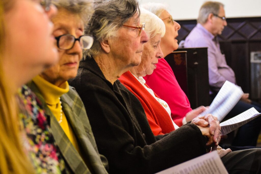 Senior ministry members worshiping together in church pews